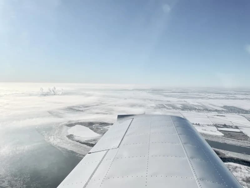 Kleinflugzeug beim Anflug über Landschaft